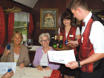 Gäste im roten Speisewagen mit freundlicher Bedienung Foto: DNV-Tours